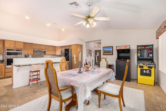 dining space with ceiling fan, lofted ceiling, and light tile patterned flooring