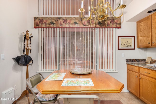 tiled dining room featuring an inviting chandelier