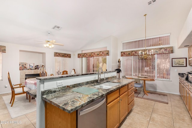 kitchen with ceiling fan with notable chandelier, sink, vaulted ceiling, stainless steel dishwasher, and decorative light fixtures