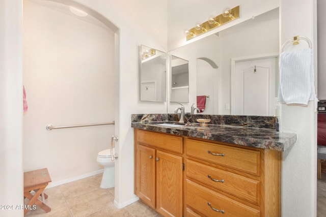 bathroom with tile patterned flooring, vanity, and toilet