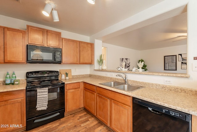 4642 E Sierrita Rd, San Tan Valley, AZ 85143 - kitchen featuring black appliances, a sink, light countertops, light wood-style flooring, and a peninsula