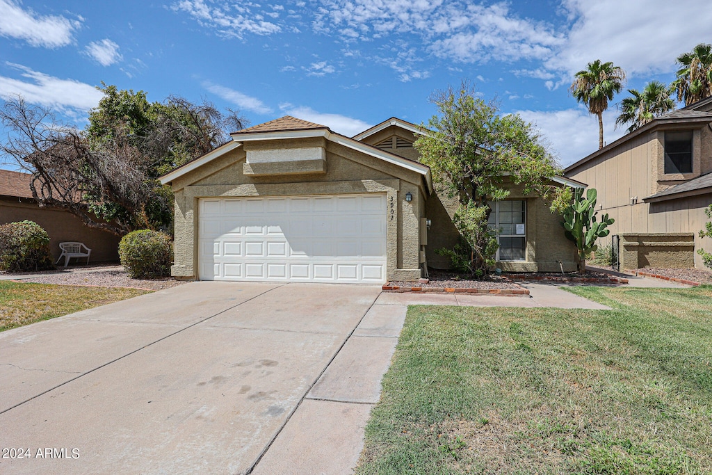 view of front of home with a front yard and a garage