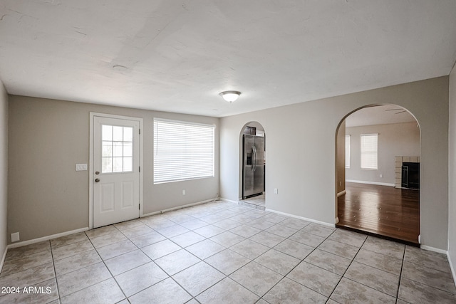 foyer with a tile fireplace and light hardwood / wood-style flooring