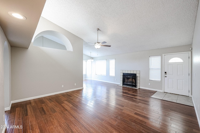 unfurnished living room with vaulted ceiling, hardwood / wood-style floors, ceiling fan, and a tile fireplace