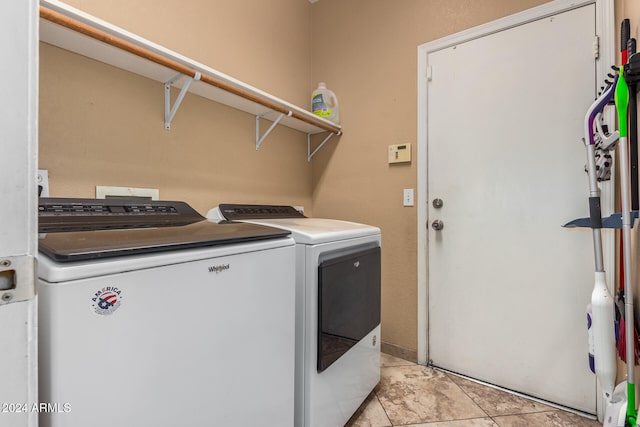 laundry room with washing machine and dryer and light tile patterned floors