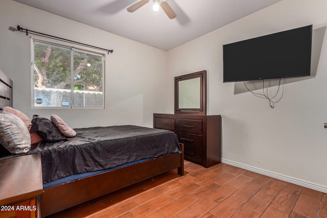 bedroom with light hardwood / wood-style floors, lofted ceiling, and ceiling fan