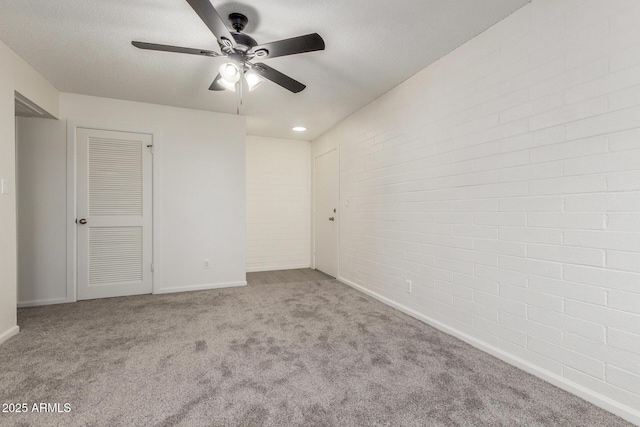 2608 W Berridge Ln Unit 220, Phoenix, AZ 85017 - unfurnished bedroom featuring carpet floors, brick wall, baseboards, and a ceiling fan