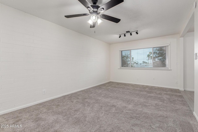 2608 W Berridge Ln Unit 220, Phoenix, AZ 85017 - empty room with carpet floors, ceiling fan, baseboards, brick wall, and track lighting