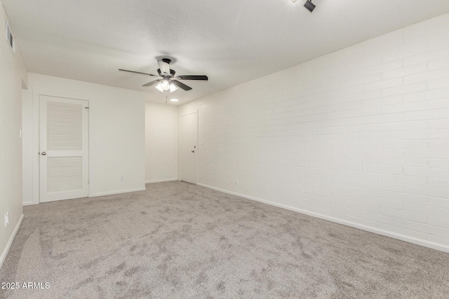 2608 W Berridge Ln Unit 220, Phoenix, AZ 85017 - carpeted empty room featuring a ceiling fan, baseboards, and brick wall