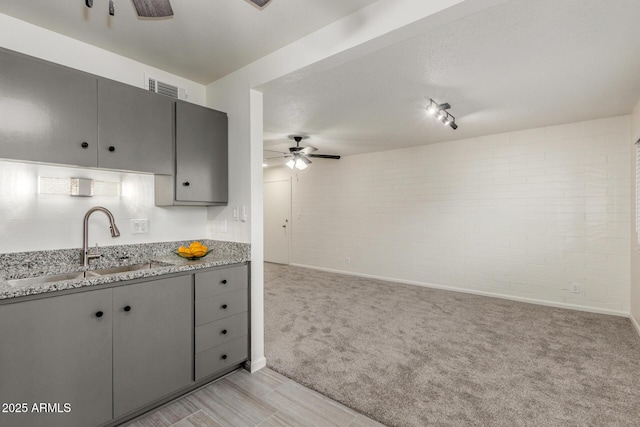 2608 W Berridge Ln Unit 220, Phoenix, AZ 85017 - kitchen featuring a ceiling fan, gray cabinetry, a sink, light carpet, and baseboards