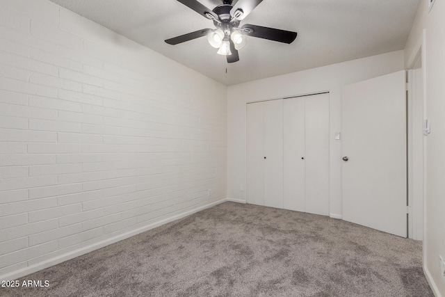 2608 W Berridge Ln Unit 220, Phoenix, AZ 85017 - unfurnished bedroom featuring carpet, a closet, brick wall, and a ceiling fan