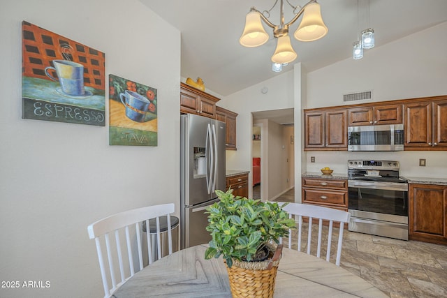 kitchen featuring stainless steel appliances, decorative light fixtures, lofted ceiling, a notable chandelier, and visible vents