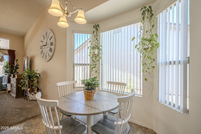 dining space featuring baseboards and a chandelier