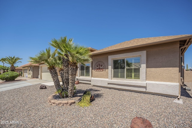view of front of home with stucco siding, driveway, and an attached garage