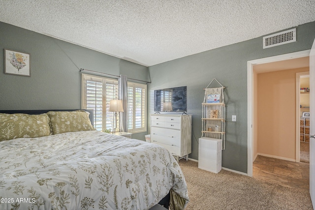 carpeted bedroom featuring visible vents and a textured ceiling