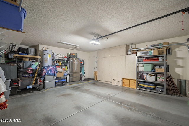 garage featuring water heater, a garage door opener, and freestanding refrigerator