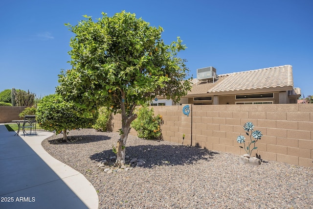 view of yard with a fenced backyard, central air condition unit, and a patio area