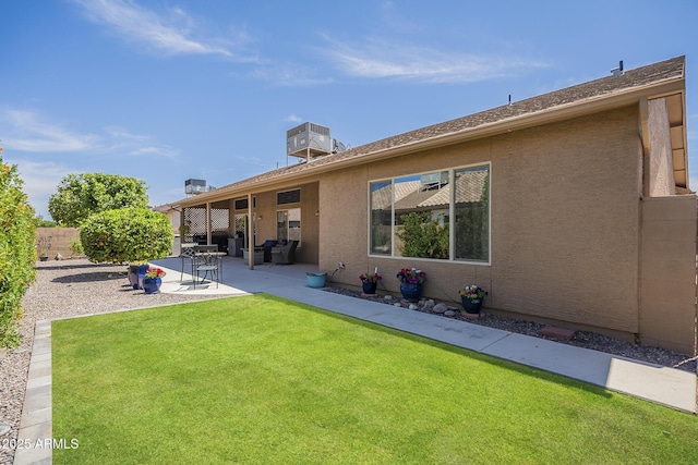 rear view of property featuring a patio area, central air condition unit, fence, a yard, and stucco siding
