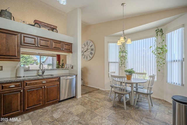 kitchen featuring baseboards, stone finish flooring, stainless steel dishwasher, and a sink