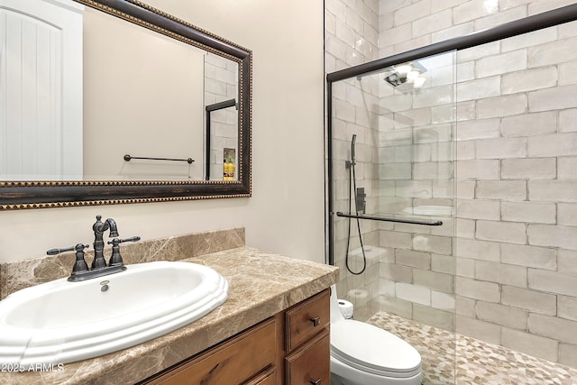 full bathroom featuring toilet, a shower stall, and vanity