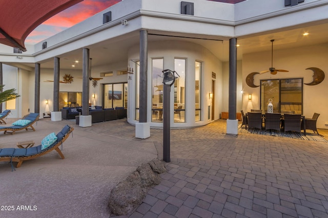 patio terrace at dusk featuring ceiling fan