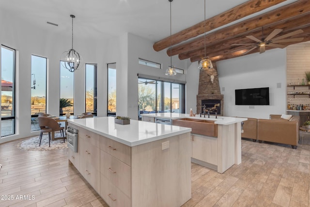 kitchen featuring pendant lighting, a fireplace, light hardwood / wood-style floors, and a kitchen island