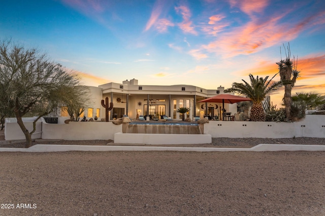 pueblo revival-style home with a patio and ceiling fan