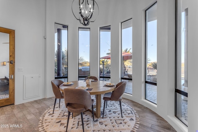 dining room with a healthy amount of sunlight, a chandelier, and light wood-type flooring