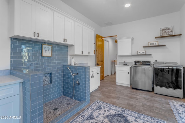 laundry area with separate washer and dryer and sink