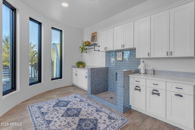 kitchen with white cabinetry, tasteful backsplash, and light hardwood / wood-style flooring