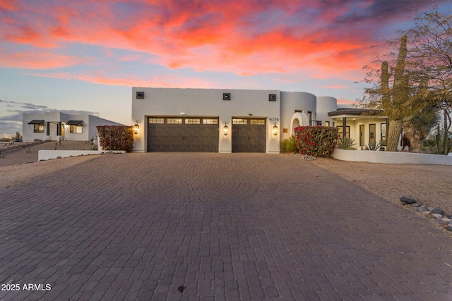 pueblo revival-style home featuring a garage