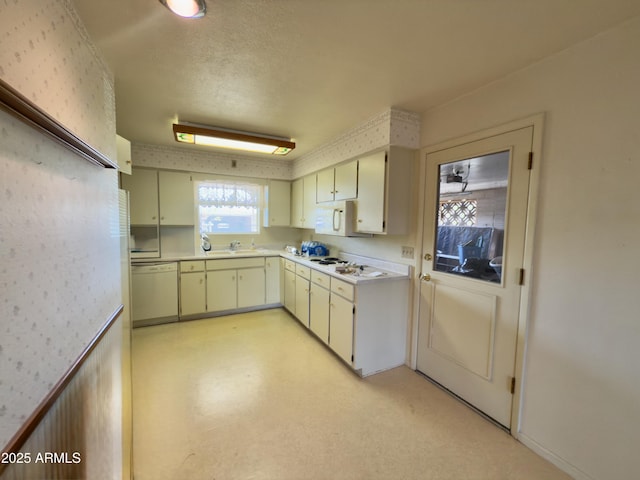 kitchen with white appliances, light countertops, a sink, and light floors