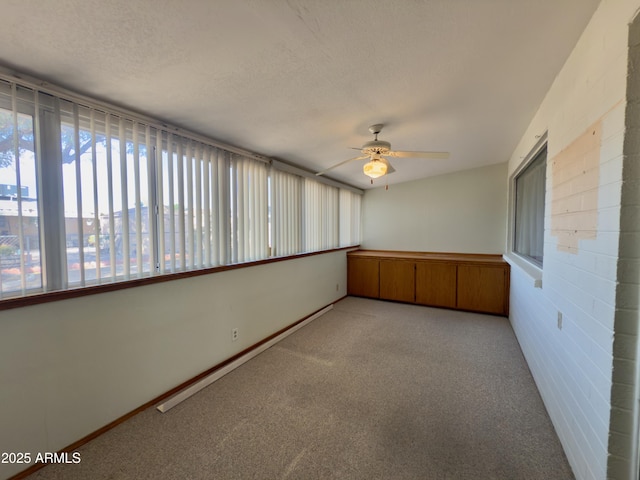 unfurnished sunroom featuring a ceiling fan