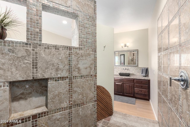 bathroom with hardwood / wood-style floors, vanity, and walk in shower