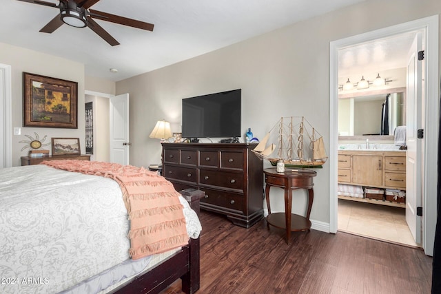 bedroom with dark hardwood / wood-style flooring, ensuite bath, ceiling fan, and sink