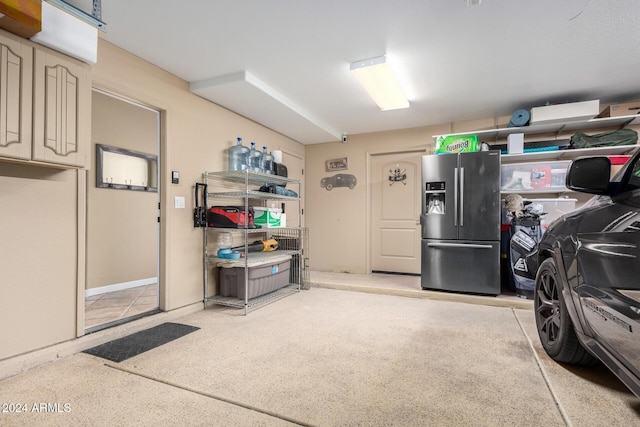 garage featuring stainless steel fridge with ice dispenser