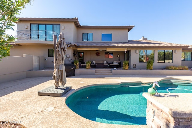 back of house with outdoor lounge area, a patio area, and a balcony