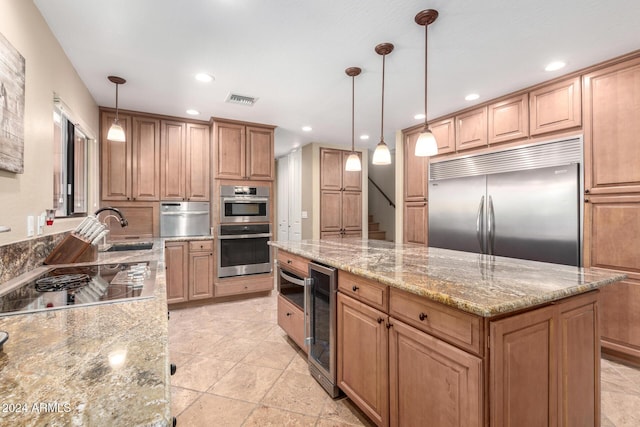 kitchen featuring pendant lighting, sink, wine cooler, light stone counters, and stainless steel appliances