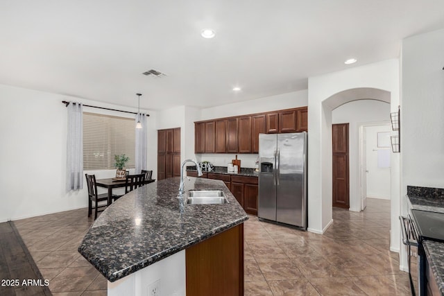 2986 E Country Shadows St, Gilbert, AZ 85298 - kitchen with stainless steel appliances, a sink, arched walkways, a center island with sink, and pendant lighting