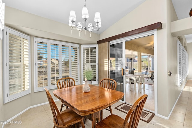 tiled dining room with lofted ceiling and a chandelier