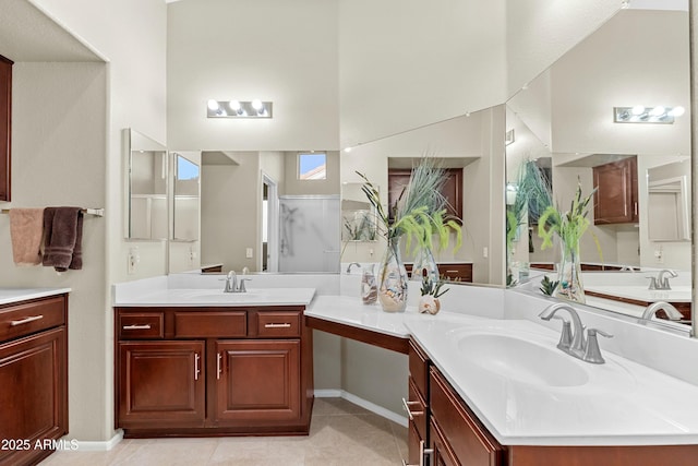 bathroom with a shower with door, vanity, and tile patterned flooring