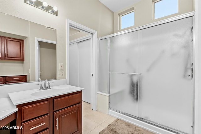 bathroom featuring vanity, tile patterned flooring, and a shower with door