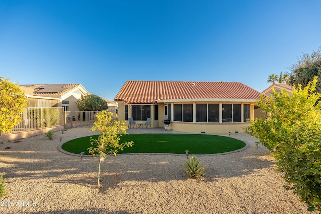 back of property with a sunroom and a lawn