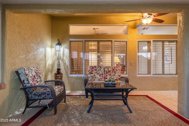 living area featuring ceiling fan and beam ceiling