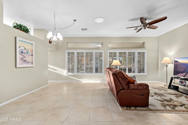 living room with ceiling fan with notable chandelier and light tile patterned flooring