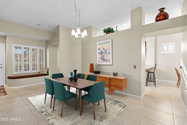 tiled dining room with a chandelier