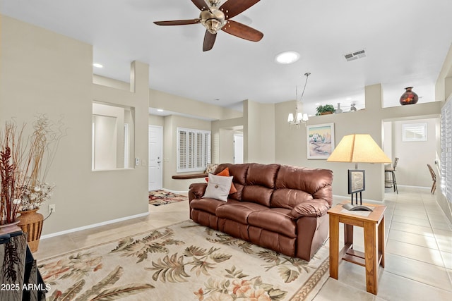 living room with light tile patterned floors and ceiling fan with notable chandelier