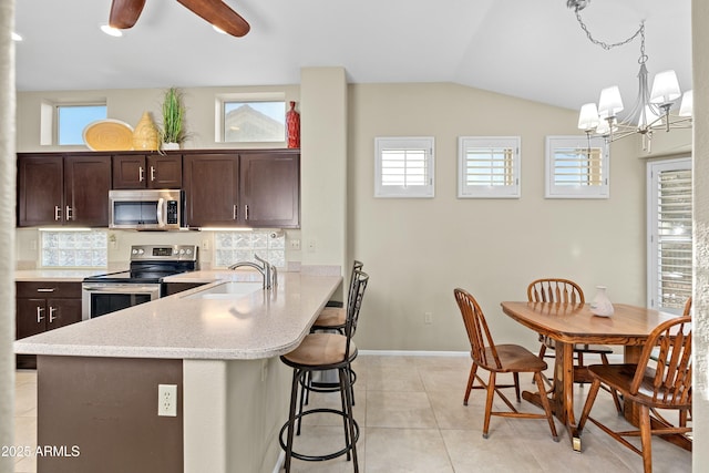 kitchen featuring appliances with stainless steel finishes, backsplash, hanging light fixtures, vaulted ceiling, and sink