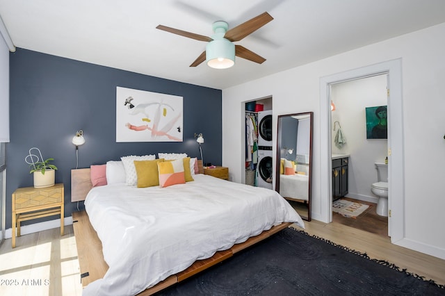 1225 E Medlock Dr Unit 206, Phoenix, AZ 85014 - bedroom with stacked washer / drying machine, light wood-type flooring, a closet, a ceiling fan, and connected bathroom