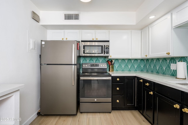 1225 E Medlock Dr Unit 206, Phoenix, AZ 85014 - kitchen featuring stainless steel appliances, white cabinetry, light countertops, and dark cabinetry